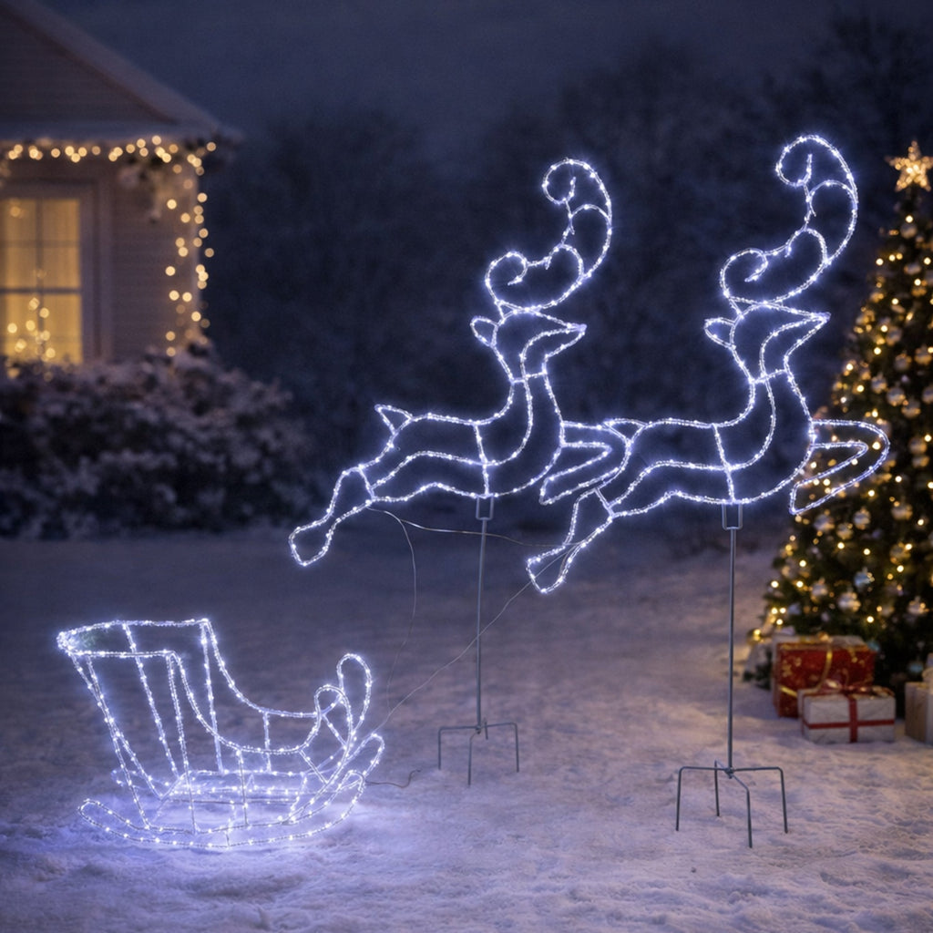Decorative LED reindeer and sleigh in front of a house with Christmas lights.